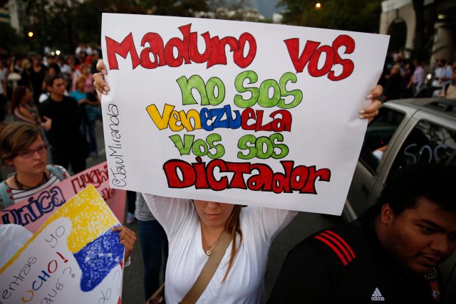 Anti-government protesters hold placards during a protest against Nicolas Maduro's government at Altamira square in Caracas
