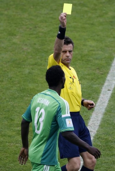 El árbitro italiano Nicola Rizzoli muestra una tarjeta amarilla al nigeriano Juwon Oshaniwa en su duelo frente a Argentina por el grupo F de la Copa del Mundo en Porto Alegre