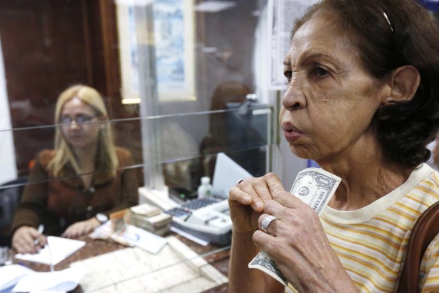 A woman changes dollars for bolivars at a money exchange in Caracas