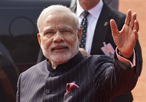 El primer ministro indio Narendra Modi viste un traje oscuro a rayas durante la visita que el presidente estadounidense Barack Obama hizo a la India en enero de 2015. Este mismo traje fue subastado por casi 700.000 dólares, se informó el viernes 20 de febrero de 2015. (Foto AP/Saurabh Das)