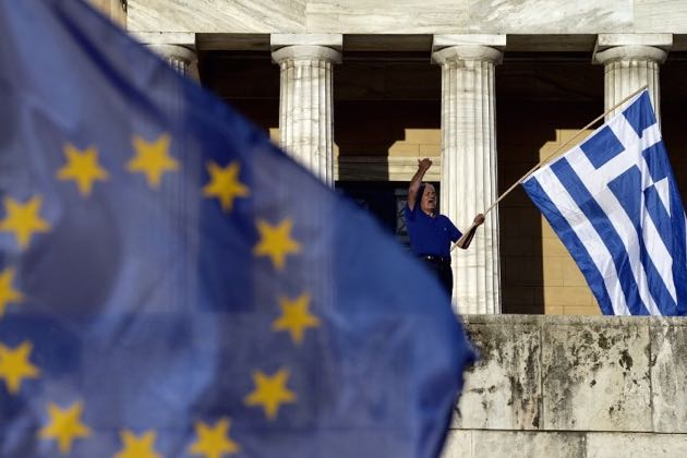 TOPSHOTS A protester shouts slogans during a pro-European demonstration in front of the Greek parliament in Athens on June 22, 2015. Greece's international lenders raised hopes for a vital bailout agreement this week to save Athens from default and a possible euro exit, despite warning no deal was likely at an emergency summit . AFP PHOTO / ARIS MESSINIS