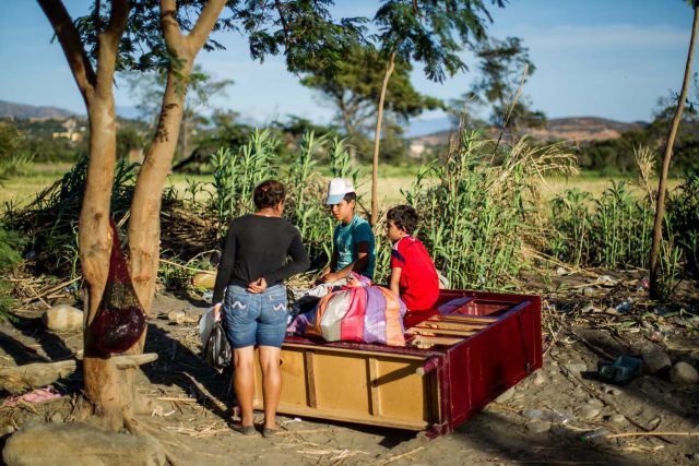 CAR19. CÚCUTA (COLOMBIA), 29/08/2015.- Dos niños descansan sobre un armario en una trocha del sector "La Parada" luego de cruzar el río Táchira, que divide a Venezuela y Colombia, hoy, sábado 29 de agosto de 2015, en el sector "La Invasión", cerca a Cúcuta (Colombia). La frontera entre Venezuela y Colombia está cerrada desde el 19 de agosto en el puente Simón Bolívar, que comunica al departamento de Cúcuta (Colombia) con San Antonio (Venezuela), por orden del presidente venezolano, Nicolás Maduro, como parte de una campaña contra el contrabando y supuestos paramilitares, que incluyó la declaración del estado de excepción en seis municipios y la deportación de más de mil colombianos. EFE/MIGUEL GUTIÉRREZ