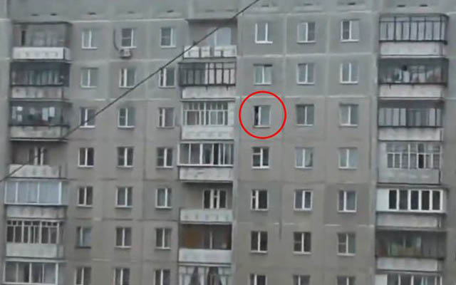 toddler-dangles-out-of-window-of-block-of-flats