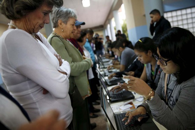 People register to cast their vote at a polling station during a legislative election, in Caracas December 6, 2015. REUTERS/Carlos Garcia Rawlins