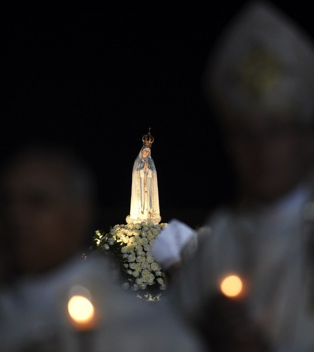 The statue of Our Lady of Fatima is carried at the Fatima shrine in central Portugal on May 12, 2016. Thousands of pilgrims converged on Fatima Sanctuary to celebrate the 99th anniversary of the Fatima's miracle when three shepherd children claimed to have seen the Virgin Mary in May 1917. / AFP PHOTO / FRANCISCO LEONG