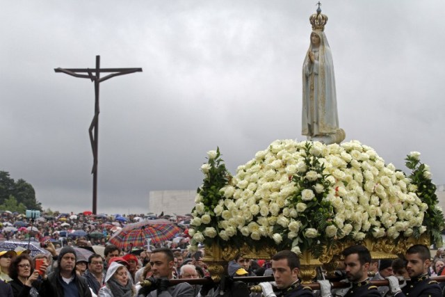 A statue of Our Lady of Fatima is carried to the Lord's table during a ceremony at the Fatima shrine in central Portugal on May 13, 2016.  Thousands of pilgrims converged on Fatima Sanctuary to celebrate the 99th anniversary of the Fatima's miracle when three shepherd children claimed to have seen the Virgin Mary in May 1917. / AFP PHOTO / JOSE MANUEL RIBEIRO