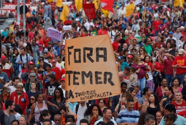 Con un letrero que dice "Fuera Temer", manifestantes marchan en contra del presidente interino de Brasil, Michel Temer, y en apoyo a la suspendida mandataria, Dilma Rousseff, el domingo 22 de mayo de 2016 en Río de Janeiro, Brasil. (Foto AP/Andre Penner)