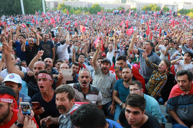 Members of the public cheer as Turkish Prime Minister Binali Yildirim (not pictured) speaks after a meeting with the Turkish Speaker of Parliament at the Turkish Grand Assembly in Ankara on July 16, 2016 following a failed coup attempt. Turkish authorities said they had regained control of the country on July 16 after thwarting a coup attempt by discontented soldiers to seize power from President Recep Tayyip Erdogan that claimed more than 250 lives. / AFP PHOTO / ADEM ALTAN