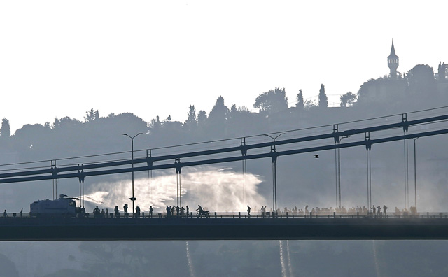 A police armored vehicle uses a water cannon to disperse anti-goverment forces on Bosphorus Bridge in Istanbul, Turkey, July 16, 2016. REUTERS/Murad Sezer