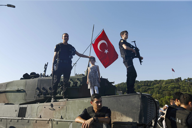 Policemen stand on a military vehicle after troops involved in the coup surrendered on the Bosphorus Bridge in Istanbul, Turkey July 16, 2016. REUTERS/Murad Sezer