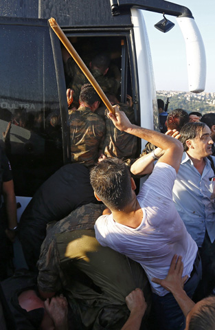Soldiers are beaten by the mob as they board a bus after troops involved in the coup surrendered on the Bosphorus Bridge in Istanbul, Turkey July 16, 2016. REUTERS/Murad Sezer