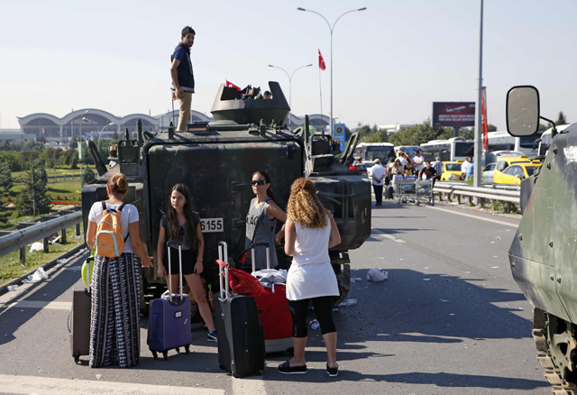 Women stand behind a military vehicle in front of Sabiha Airport, in Istanbul, Turkey July 16, 2016. REUTERS/Baz Ratner