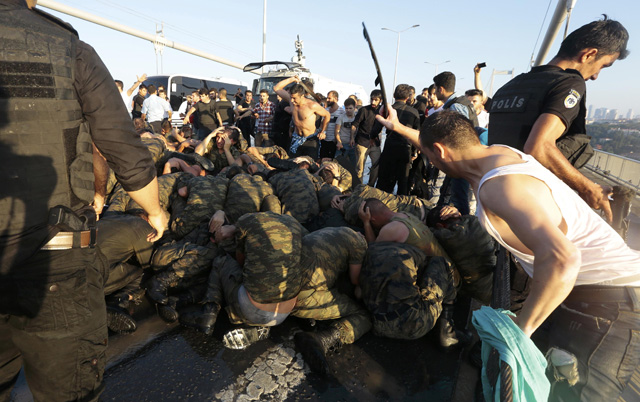 Surrendered Turkish soldiers who were involved in the coup are beaten by civilians on Bosphorus bridge in Istanbul, Turkey, July 16, 2016. REUTERS/Stringer EDITORIAL USE ONLY. NO RESALES. NO ARCHIVES.