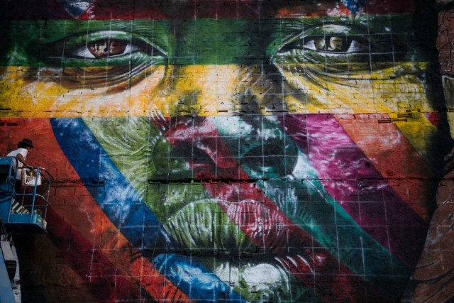 Asistentes al artista brasileño Eduardo Kobra trabajan en la pintura de un enorme mural que representa los cinco continentes, en el Olympic Boulevard, en Río de Janeiro, Brasil, el 14 de julio de 2016. CHRISTOPHE SIMON / AFP