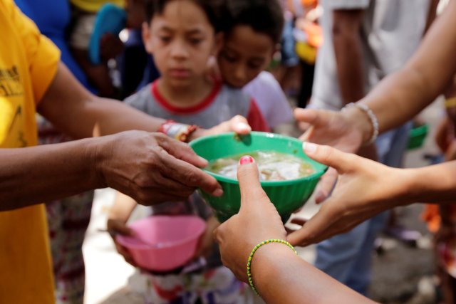 Children queue as they wait to receive free food which was prepared by residents and volunteers on a street in the low-income neighborhood of Caucaguita in Caracas, Venezuela September 17, 2016. REUTERS/Henry Romero