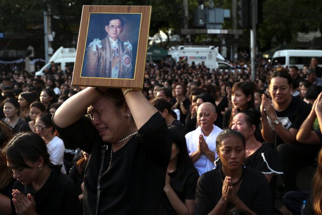 A woman cries while holding up a portrait of Thailand's King Bhumibol Adulyadej while his body is being moved from the Bangkok hospital where he died to the Grand Palace, in Bangkok, Thailand, October 14, 2016. REUTERS/Athit Perawongmetha TPX IMAGES OF THE DAY