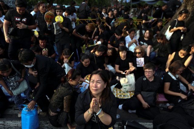 Mourners pray while the body of Thailand's King Bhumibol Adulyadej is being moved from the Bangkok hospital where he died to the Grand Palace, in Bangkok, Thailand, October 14, 2016. REUTERS/Athit Perawongmetha