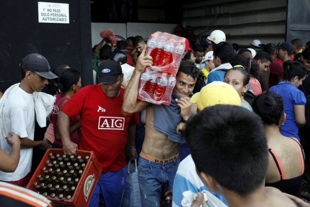 People carry goods taken from a food wholesaler after it was broken into, in La Fria, Venezuela December 17, 2016. REUTERS/Carlos Eduardo Ramirez