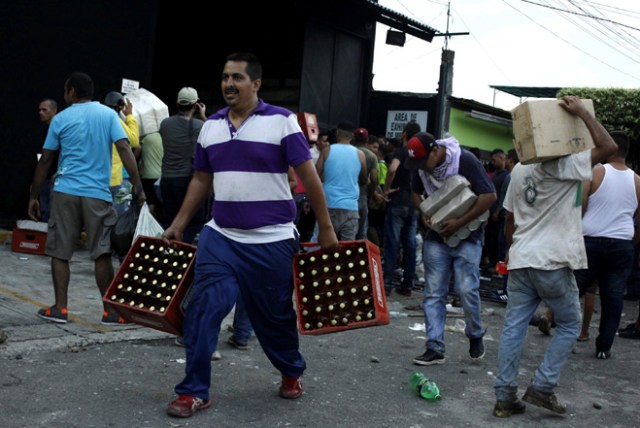 People carry goods taken from a food wholesaler after it was broken into, in La Fria, Venezuela December 17, 2016. REUTERS/Carlos Eduardo Ramirez