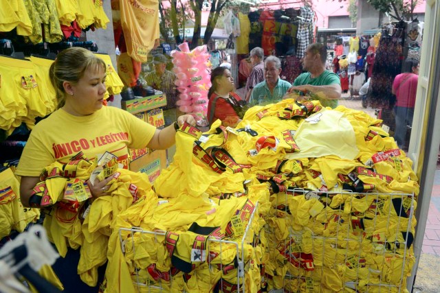 A vendor arranges yellow underwear for sell at a store in Medellin, Colombia, on December 29, 2016, where tradition holds that it brings prosperity and good luck if you wear it on New Year's Eve. / AFP PHOTO / CAMILO GIL