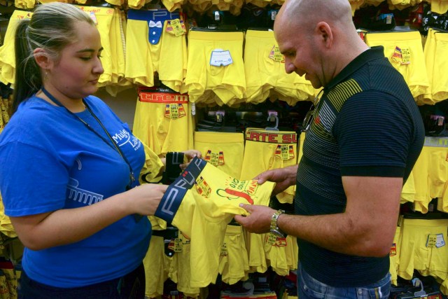 A customer looks at yellow underwear for sell at a store in Medellin, Colombia, on December 29, 2016, where tradition holds that it brings prosperity and good luck if you wear it on New Year's Eve. / AFP PHOTO / CAMILO GIL