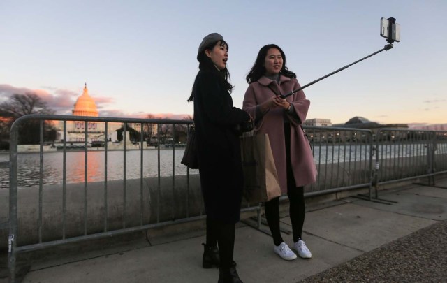 WASHINGTON, DC - JANUARY 18: People take photos as the sun sets on the West Front of the U.S. Capitol building ahead of inauguration ceremonies there for President-elect Donald Trump on January 18, 2017 in Washington, DC. Trump will be sworn in as the 45th U.S, president on January 20.   Mario Tama/Getty Images/AFP