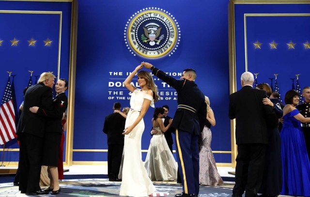 President Donald Trump, left, dances with Navy Petty Officer 2nd Class Catherine Cartmell as first lady Melania Trump is spun by Army Staff Sgt. Jose A. Medina during a dance at The Salute To Our Armed Services Inaugural Ball in Washington, Friday, Jan. 20, 2017. (AP Photo/Alex Brandon)