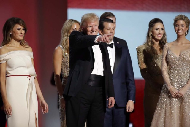 President Donald Trump, center, acknowledges supporters after dancing with first lady Melania Trump, left, and family at the Liberty Ball, Friday, Jan. 20, 2017, in Washington. (AP Photo/Patrick Semansky)