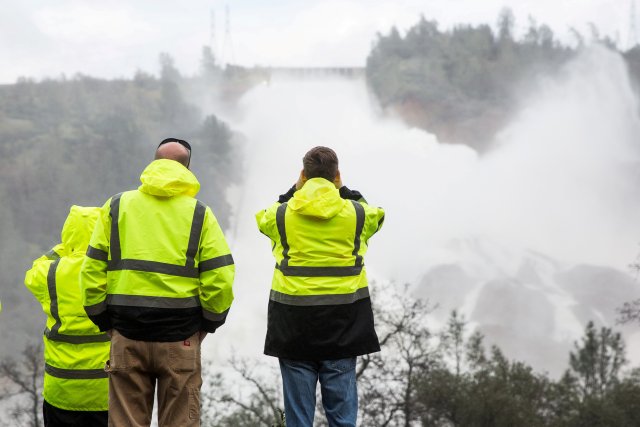 FILE PHOTO:  California Department of Water Resources personnel monitor water flowing through a damaged spillway on the Oroville Dam in Oroville, California, U.S., on February 10, 2017. REUTERS/Max Whittaker/File Photo