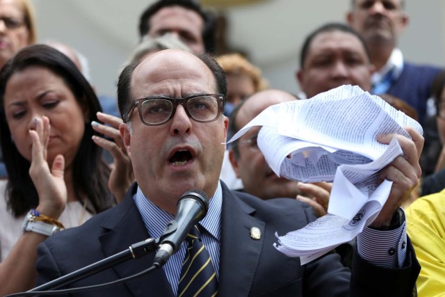 Julio Borges, President of the National Assembly holds a teared copy of a sentence of the Venezuela's Supreme Court as he speaks during a news conference in Caracas, Venezuela March 30, 2017. REUTERS/Carlos Garcia Rawlins