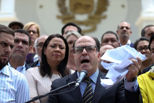 Julio Borges (C), President of the National Assembly holds a teared copy of a sentence of the Venezuela's Supreme Court as he speaks during a news conference in Caracas, Venezuela March 30, 2017. REUTERS/Carlos Garcia Rawlins