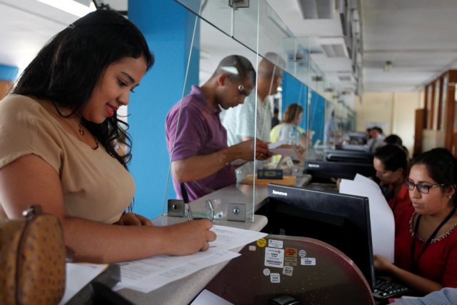Una ciudadana venezolana firma documentos para obtener su Permiso Temporal de Permanencia en Perú el 6 de febrero de 2017. Credit Guadalupe Pardo/Reuters