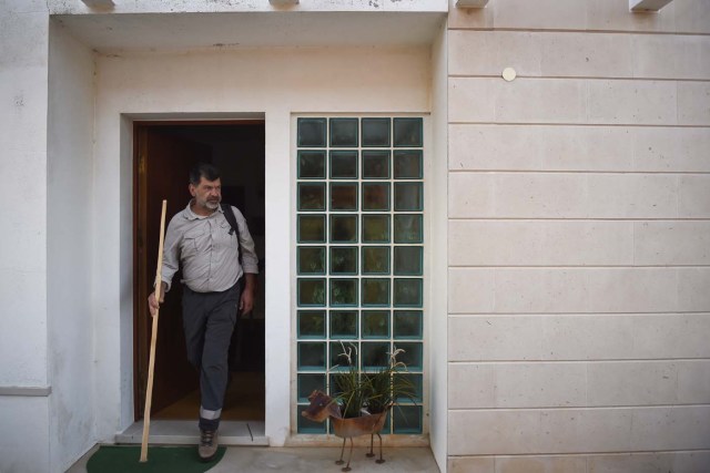 Carlos Gil leaves his house on the morning he and his sister started the walk to Fatima, in Cascais, outskirts of Lisbon, on May 5, 2017.  Carlos Gil is a payer-off of promises, at least that is the way the Roman Catholic refers to himself. But he is more commonly known as a rent-a-pilgrim. This 52-year-old Portuguese national takes on pilgrimages by proxy (in the name of others), especially Catholics unable to fulfil the journey because of sickness or too busy or lazy to undertake the week-long spiritual walk to the central Portuguese town of Fatima. He can be hired for an average cost of 2,500 euros. / AFP PHOTO / PATRICIA DE MELO MOREIRA / TO GO WITH AFP STORY BY BRIGITTE HAGEMANN
