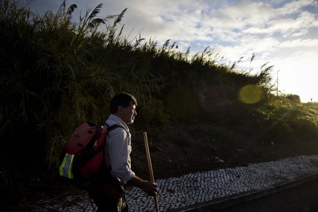 Carlos Gil starts his walk to Fatima with a backpack on his shoulders, in Cascais, outskirts of Lisbon, on May 5, 2017.  Carlos Gil is a payer-off of promises, at least that is the way the Roman Catholic refers to himself. But he is more commonly known as a rent-a-pilgrim. This 52-year-old Portuguese national takes on pilgrimages by proxy (in the name of others), especially Catholics unable to fulfil the journey because of sickness or too busy or lazy to undertake the week-long spiritual walk to the central Portuguese town of Fatima. He can be hired for an average cost of 2,500 euros. / AFP PHOTO / PATRICIA DE MELO MOREIRA / TO GO WITH AFP STORY BY BRIGITTE HAGEMANN