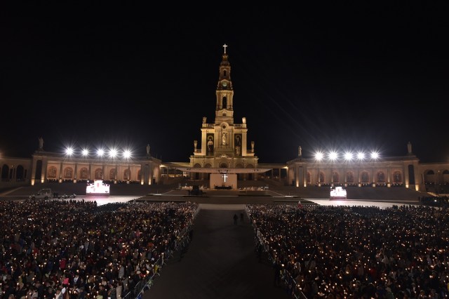 Pilgrims hold candles at the Shrine of Fatima during the Blessing for the Candles from the Chapel of the Apparitions by Pope Francis, in Fatima on May 12, 2017. Two of the three child shepherds who reported apparitions of the Virgin Mary in Fatima, Portugal, one century ago, will be declared saints on May 13, 2017 by Pope Francis. The canonisation of Jacinta and Francisco Marto will take place during the Argentinian pontiff's visit to a Catholic shrine visited by millions of pilgrims every year. / AFP PHOTO / TIZIANA FABI