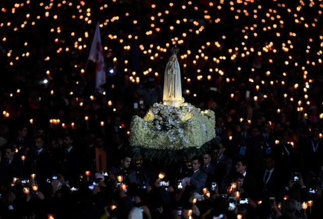 Faithful carry the statue of Our Lady of Fatima at Fatima shrine, in Fatima, on May 12, 2017. Two of the three child shepherds who reported apparitions of the Virgin Mary in Fatima, Portugal, one century ago, will be declared saints on May 13, 2017 by Pope Francis. The canonisation of Jacinta and Francisco Marto will take place during the Argentinian pontiff's visit to a Catholic shrine visited by millions of pilgrims every year. / AFP PHOTO / FRANCISCO LEONG
