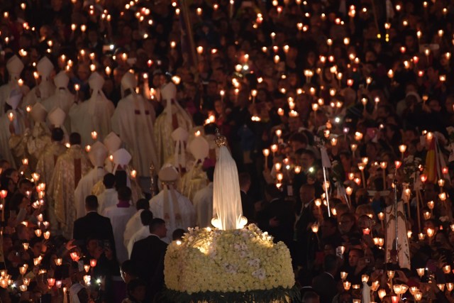 Faithful carry the statue of Our Lady of Fatima at Fatima shrine, in Fatima, on May 12, 2017. Two of the three child shepherds who reported apparitions of the Virgin Mary in Fatima, Portugal, one century ago, will be declared saints on May 13, 2017 by Pope Francis. The canonisation of Jacinta and Francisco Marto will take place during the Argentinian pontiff's visit to a Catholic shrine visited by millions of pilgrims every year. / AFP PHOTO / Tiziana FABI