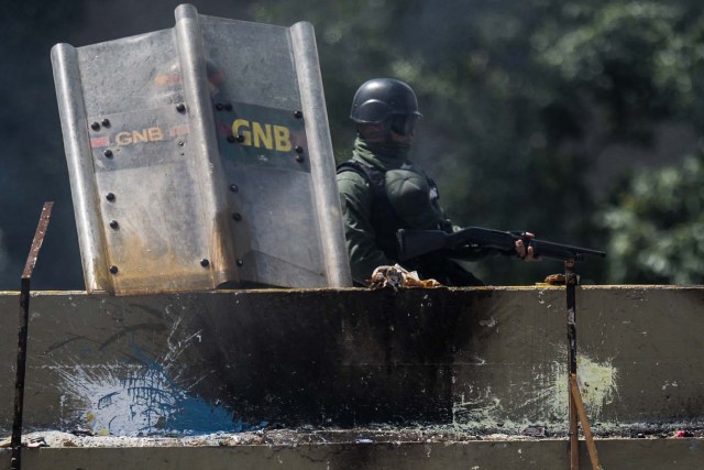 Riot police officers confront opposition activists during a demonstration against Venezuelan President Nicolas Maduro in Caracas, on May 26, 2017. Riot police in Venezuela fired tear gas and water cannon to stop anti-government protesters from marching on a key military installation Friday during the latest violence in nearly two months of unrest. / AFP PHOTO / Federico PARRA