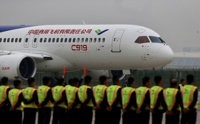 Members of staff stand in front of China's home-grown C919 passenger jet after it lands during its maiden flight at the Pudong International Airport in Shanghai, China May 5, 2017. REUTERS/Stringer ATTENTION EDITORS - THIS IMAGE WAS PROVIDED BY A THIRD PARTY. EDITORIAL USE ONLY. CHINA OUT. NO COMMERCIAL OR EDITORIAL SALES IN CHINA.
