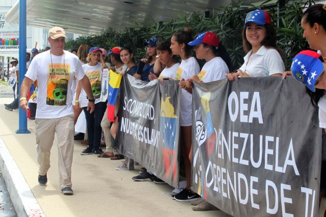 MEX01. CANCÚN (MÉXICO), 18/06/2017.- Ciudadanos venezolanos se reúnen hoy, domingo 18 de junio de 2017, en torno al hotel sede de la reunión de Organización de Estados Americanos (OEA), que dará inicio este lunes en la ciudad de Cancún, en el estado de Quintana Roo (México). La Organización de Estados Americanos (OEA) buscará soluciones a la crisis de Venezuela mañana en una reunión de cancilleres previa a su 47 Asamblea General, que tendrá lugar hasta el 21 de junio en Cancún, en el Caribe mexicano. El tema oficial de la Asamblea es "Fortaleciendo el diálogo y la concertación para la prosperidad", pero el asunto de fondo que definirá la cita será la posición de la región sobre la crisis política y social venezolana. EFE/ Alonso Cupul