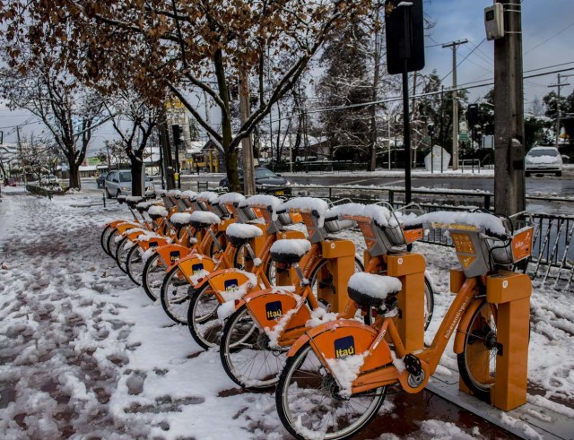 View of bicycles covered with snow in Santiago on July 15, 2017.  An unusual snowfall --the first of such intensity since 2007-- surprised the inhabitants of the Chilean capital, causing a few power cuts and minor traffic jams, in particular in the eastern areas of the capital, the closest to the Andes mountain range. / AFP PHOTO / MARTIN BERNETTI