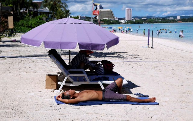 Tourists enjoy the beach in the Tumon tourist district on the island of Guam, a U.S. Pacific Territory, August 12, 2017. REUTERS/Erik De Castro