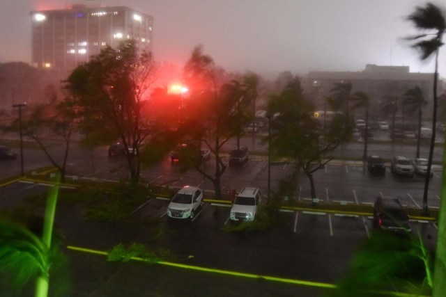 Branches lie on the ground as trees blow in the wind from the passage of the Hurricane Maria, seen outside Roberto Clemente Coliseum where residents have sought shelter in San Juan, Puerto Rico, early on September 20, 2017. Hurricane Maria closed in on the Virgin Islands and Puerto Rico on September 20 as forecasters warned of a "potentially catastrophic" storm that has already killed at least two people in the Caribbean. / AFP PHOTO / HECTOR RETAMAL