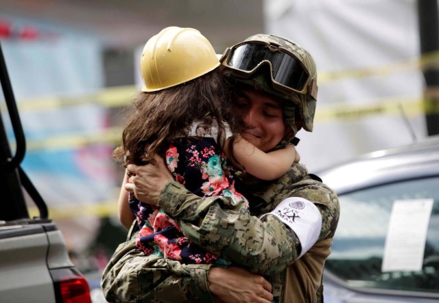 A girl hugs a Mexican marine officer as she offers hugs to people near the site of a collapsed building after an earthquake, in Mexico City, Mexico September 23, 2017. REUTERS/Jose Luis Gonzalez TPX IMAGES OF THE DAY