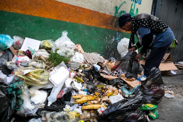 ACOMPAÑA CRÓNICA: VENEZUELA CRISIS. CAR09. CARACAS (VENEZUELA), 25/09/2017.- Fotografía fechada el 20 de septiembre de 2017 que muestra a una mujer mientras hurga en una basura en busca de comida en una calle de Caracas (Venezuela). En las calles de Caracas deambulan cada vez más niños y de menos edad. Se trata, según analistas y activistas de derechos humanos, de una nueva oleada de pequeños que prácticamente han abandonado sus hogares, aunque esta vez la razón es una sola: "La falta de comida en sus casas". EFE/Miguel Gutiérrez