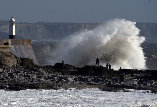 Waves crash over the lighthouse as storm Ophelia approaches Porthcawl, Wales, Britain October 16, 2017. REUTERS/Rebecca Naden