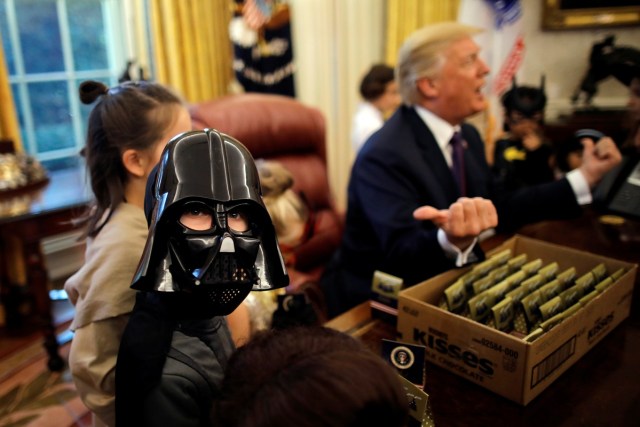 U.S. President Donald Trump gives out Halloween treats to children of members of press and White House staff at the Oval Office of the White House in Washington, U.S., October 27, 2017. REUTERS/Carlos Barria