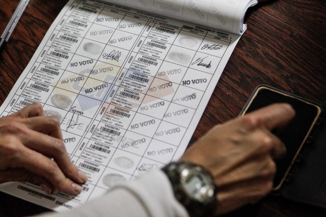 Un miembro de mesa marca con un sello a los electores que se abstuvieron en el cuaderno de votantes EFE/Cristian Hernández
