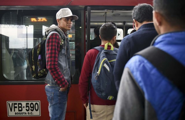 Venezuelan national Jhonger Pina, 25, awaits at a bus station in Bogota, before getting a bus to sell candies and show Bolivar bills as a curiosity to passengers in exchange for local coins, on October 26, 2017. Up to October 2017 there were 470,000 Venezuelans in Colombia, who left their country to escape the hardship and violence of its economic and political crisis. / AFP PHOTO / Raul Arboleda / TO GO WITH AFP STORY by Daniela QUINTERO and Santiago TORRADO