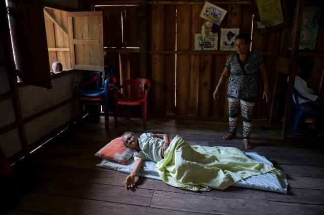 María Alegria (C), residente local de mayor edad, yace en una estera en el piso de su casa después de sufrir una mala caída, en Pital de la Costa, municipio de Tumaco, departamento de Nariño, Colombia el 31 de octubre de 2017. / Raul Arboleda